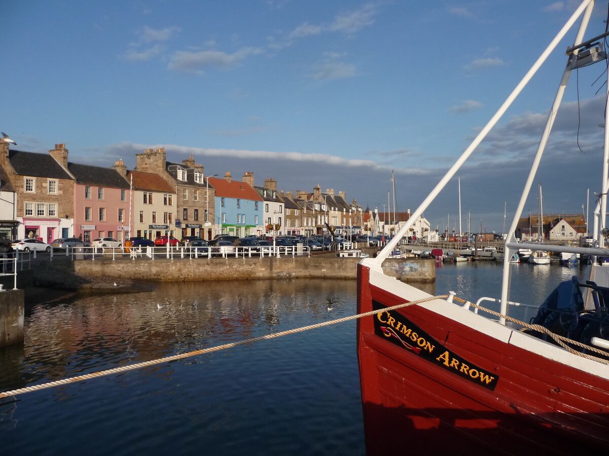 Colourful waterfront buildings and fishing boats at Anstruther harbour in Fife.